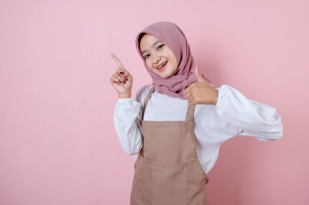 Beautiful young woman wearing apron with smile and happy