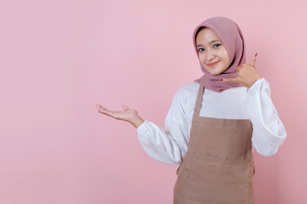Beautiful young woman wearing apron with smile and happy