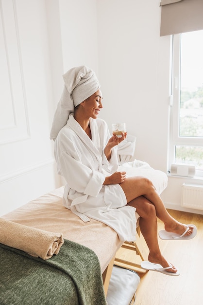 Beautiful young woman wearing bathrobe and head towel before spa treatment in a beauty salon.