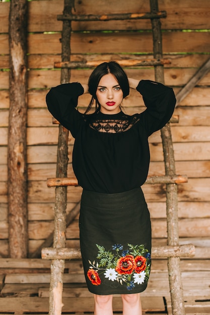 beautiful young woman wearing national ukrainian clothes  in wooden hut