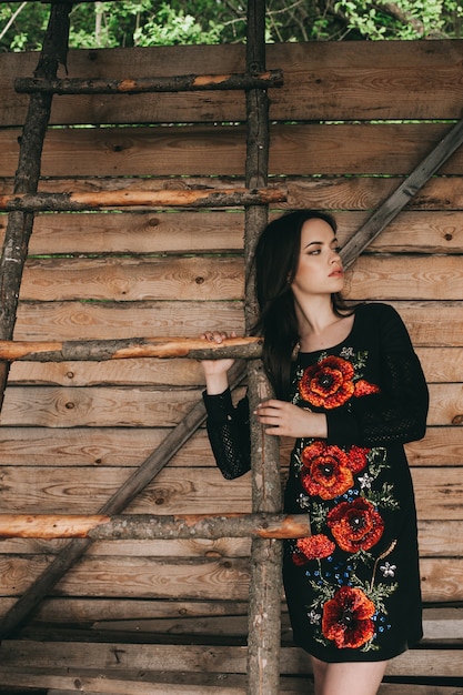 Beautiful young woman wearing national ukrainian clothes  in wooden hut