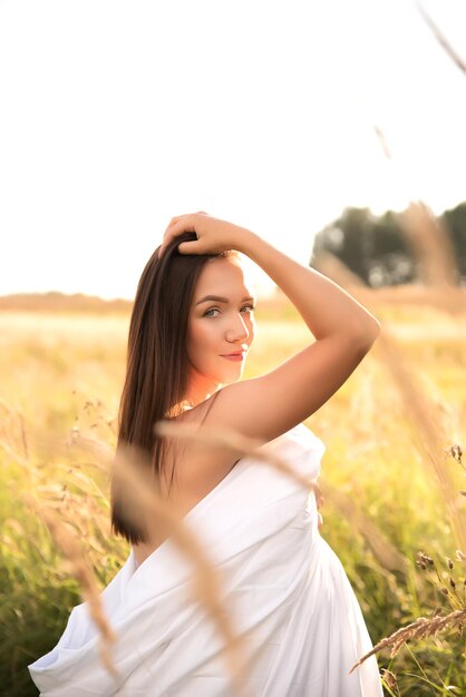 Beautiful young woman in wheat field at sunset Healthy lifestyle