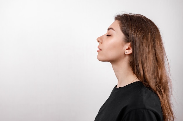 Foto bella giovane donna su bianco in una maglietta nera