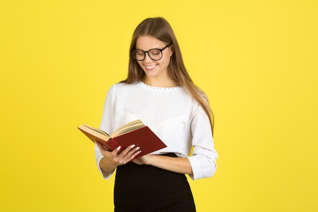 Beautiful young woman in a white shirt on a yellow background