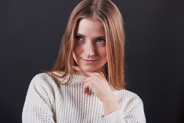 하얀 스웨터와 청바지 검은 배경에 고립에서 아름 다운 젊은 여자