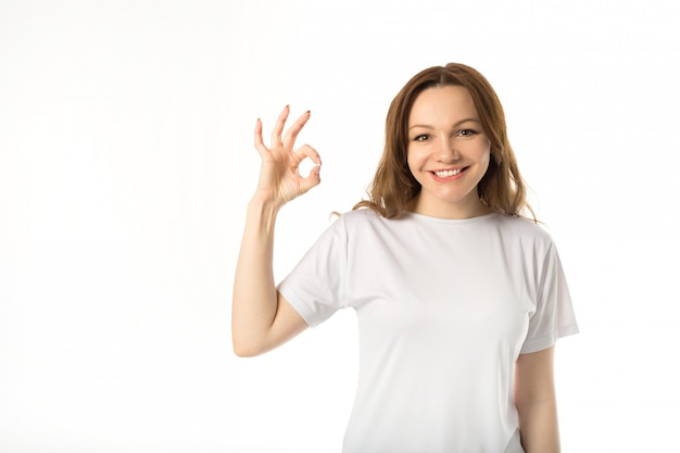 Beautiful young woman in white t-shirt with hand gesture