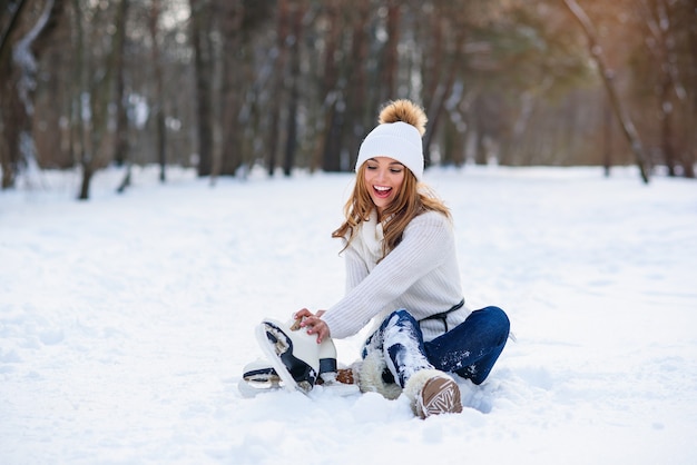 冬の雪の公園で美しい若い女性