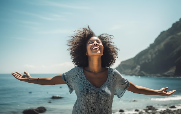 Beautiful young woman with afro hairstyle standing on the rocks by the sea