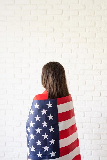 beautiful young woman with american flag rear view