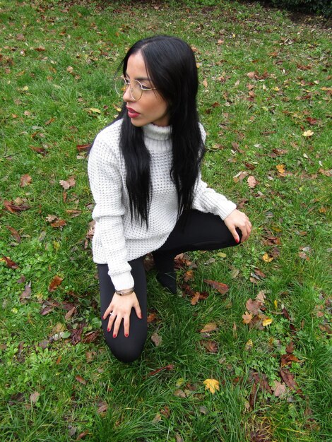 Beautiful young woman with arms raised on field