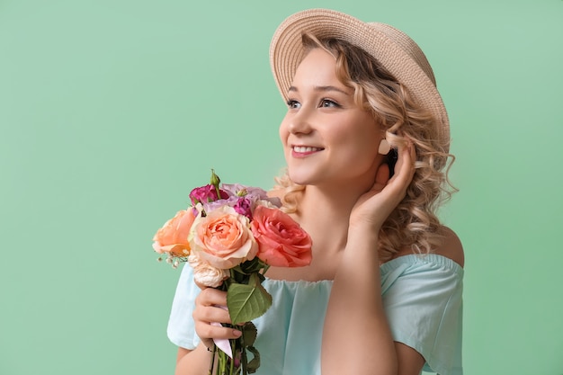 Bella giovane donna con bouquet di fiori sul colore