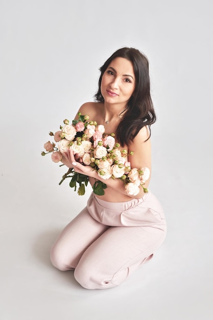 Beautiful young woman with bouquet flowers of roses International Women's Day