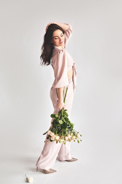 Photo beautiful young woman with bouquet flowers of roses international women's day