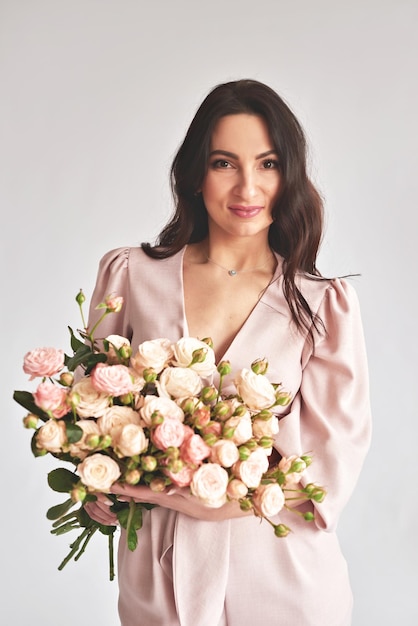 Beautiful young woman with bouquet flowers of roses International Women's Day