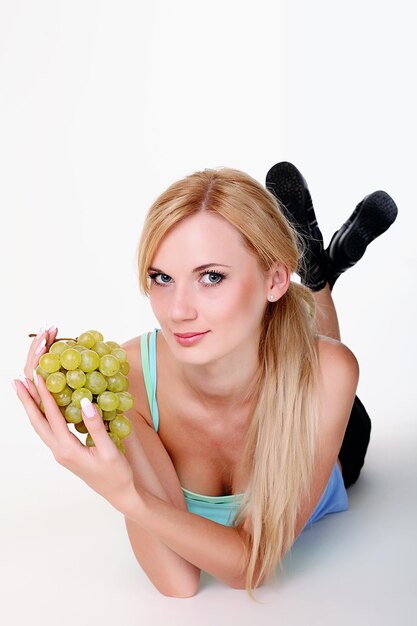 Beautiful young woman with bunch of grapes