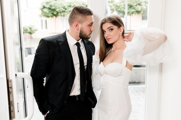 Beautiful young woman with charming beard man seriously looking at the camera fashion models concep