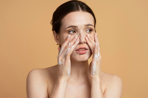 사진 청결 한 건강 한 신선 한 반이는 피부 를 가진 아름다운 젊은 여자 가 메이크업 을 하는 동안 눈 을 돌리고 있다