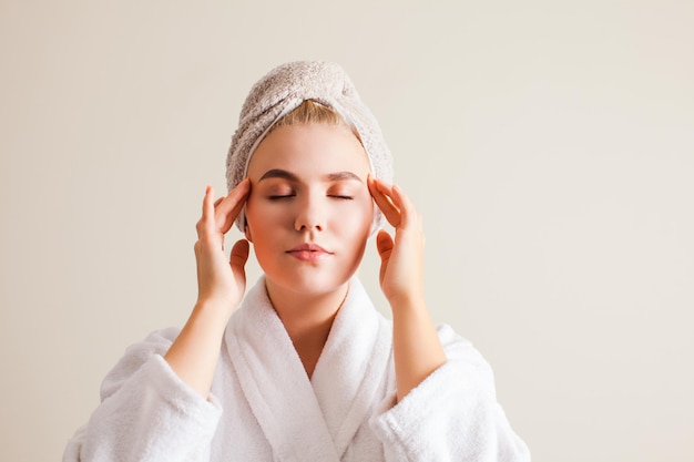 Beautiful young woman with clean perfect skin doing facial self massage at home Beauty spa skincare and wellness concept