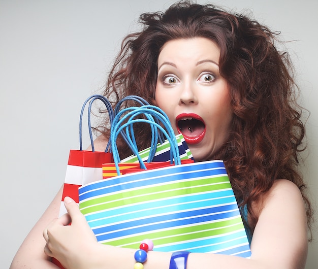 Photo beautiful young woman with colored shopping bags