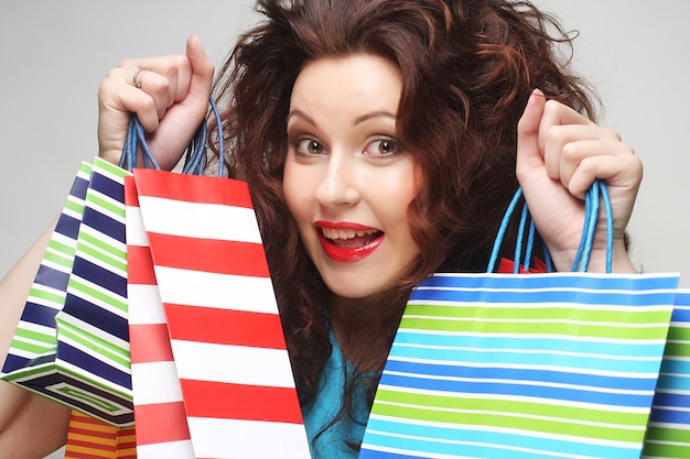 Beautiful young woman with colored shopping bags