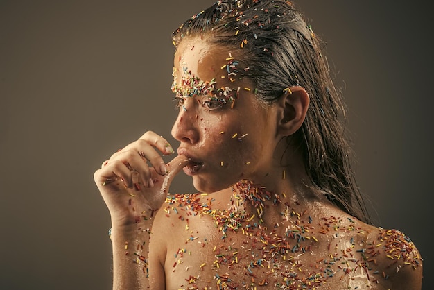 Beautiful young woman with creative makeup on grey background, closeup.