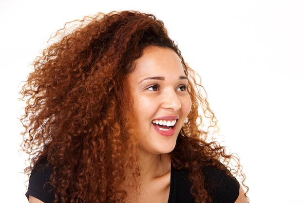 Beautiful young woman with curly hair laughing against isolated white background