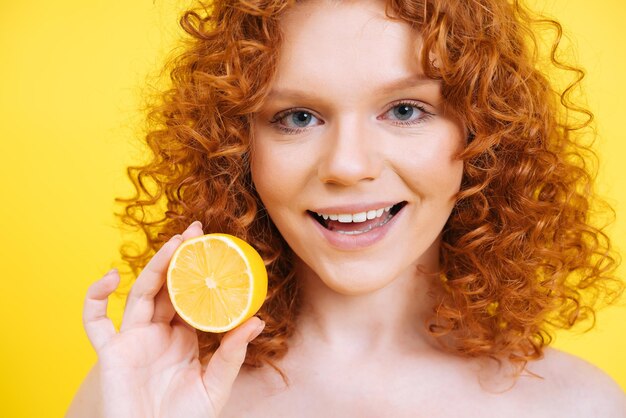 Beautiful young woman with curly red hair posing in studio for a beauty and body positive set. Concept about healthy lifestyle and food