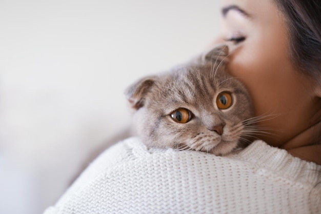 Beautiful young woman with cute cat resting at home