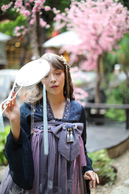 Photo beautiful young woman with dark blue chinese lolita dress with chinese garden  person