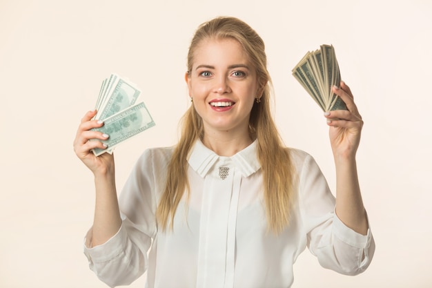 Photo beautiful young woman with dollars in her hands on a white background