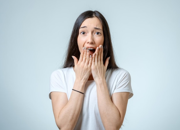 Beautiful young woman with a fear expression isolated over white background