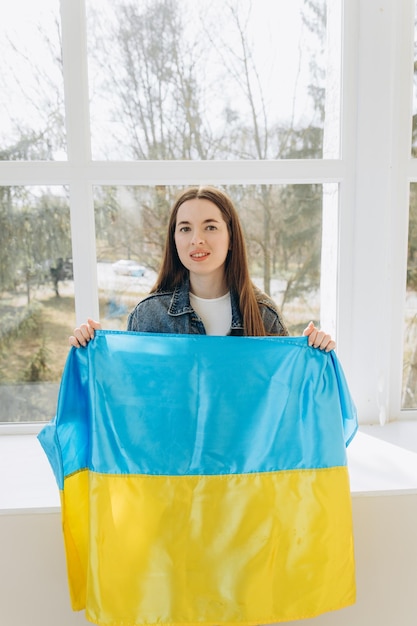 Beautiful young woman with flag of Ukraine