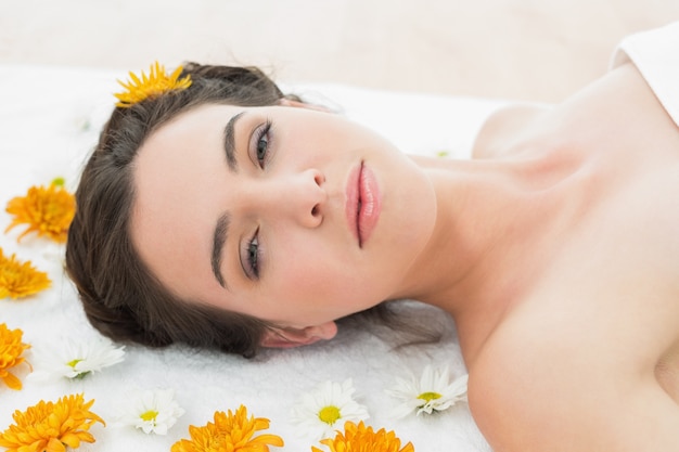 Beautiful young woman with flowers in beauty salon