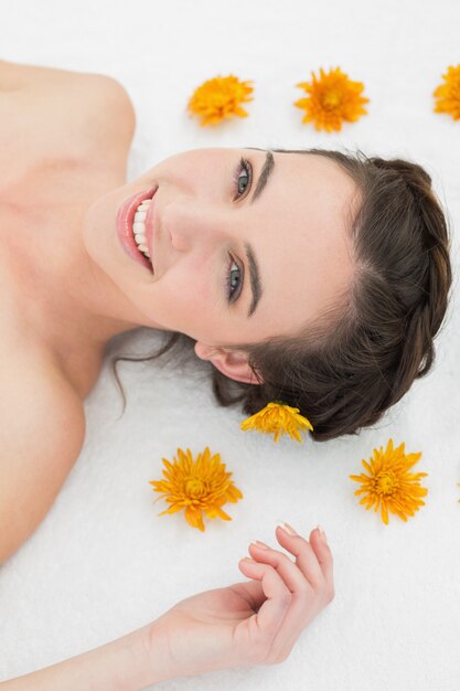 Beautiful young woman with flowers in beauty salon