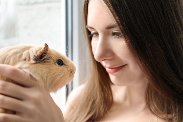 Beautiful young woman with funny guinea pig closeup