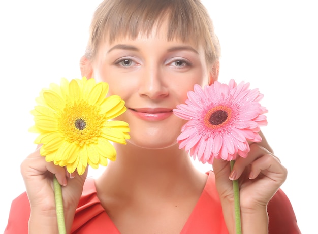 白で隔離されるガーバーの花を持つ美しい若い女性