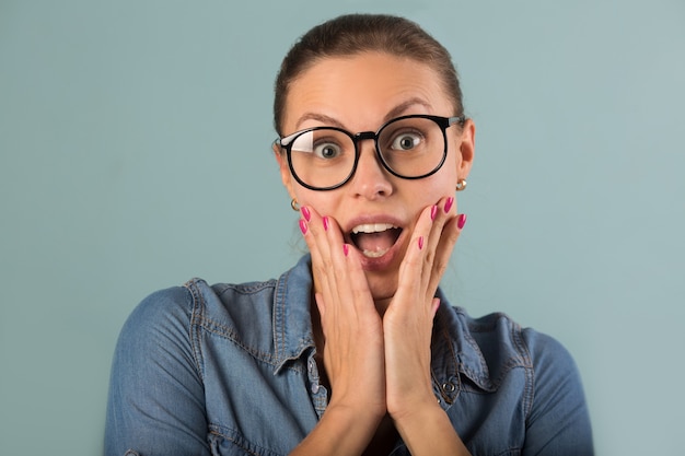 beautiful young woman with glasses on a blue background