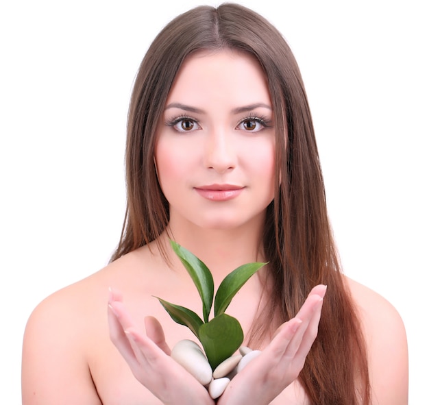 Beautiful young woman with green leafs isolated on white