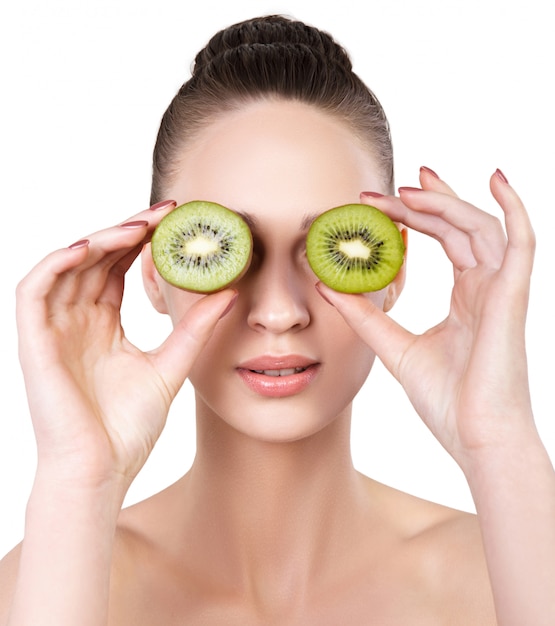 Beautiful young woman with health fresh skin and kiwi. Natural beauty treatment