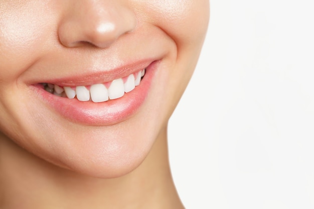 Beautiful young woman with healthy teeth on white background.