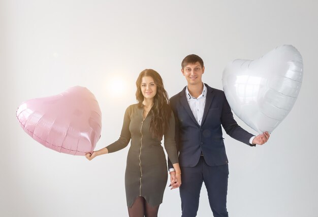 Beautiful young woman with heart shape air balloon on white background with copy space. Woman on Valentine's Day. Symbol of love.