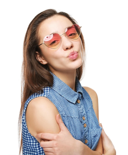 Beautiful young woman with heartshaped glasses on white background