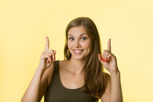 beautiful young woman with her hair on yellow wall