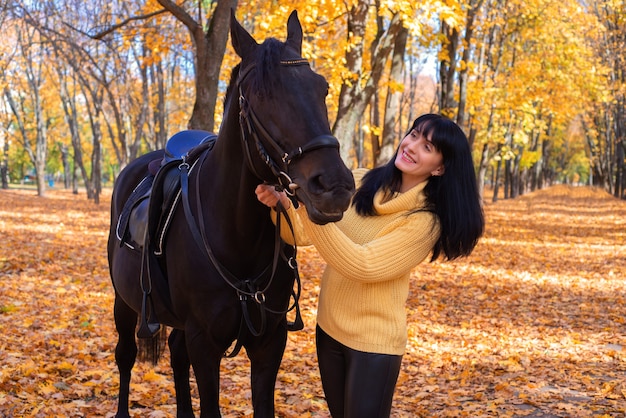 공원에서 가을에 말과 함께 아름 다운 젊은 여자