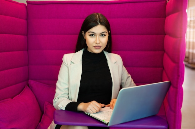 Beautiful young woman with laptop in office