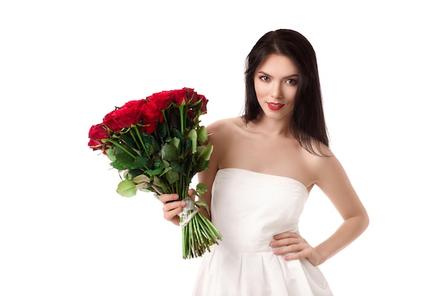 Beautiful young woman with a large bouquet of red roses