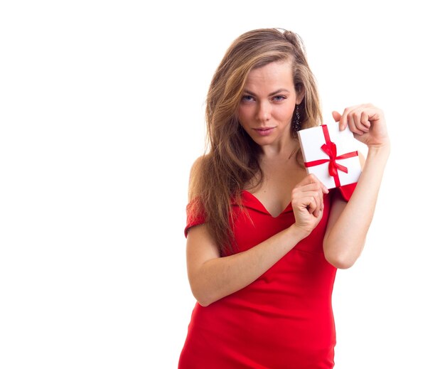 Beautiful young woman with long brown hair in skimpy red dress with black earings holding present