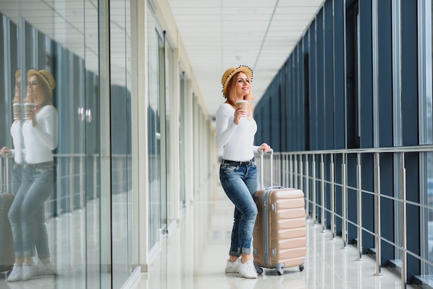 空港で荷物を持つ美しい若い女性