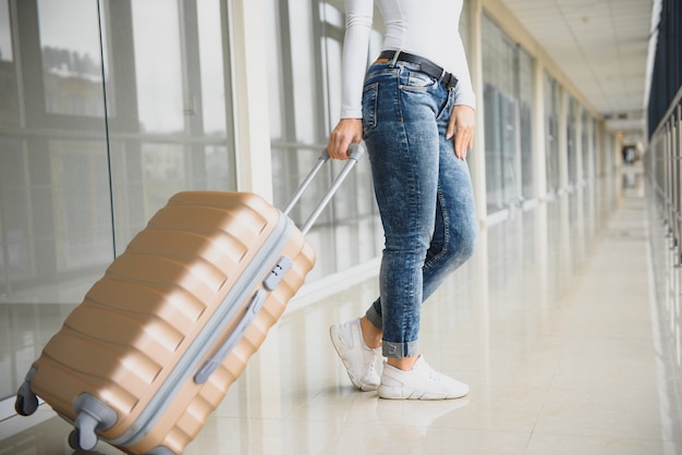 Beautiful young woman with luggage at the airport