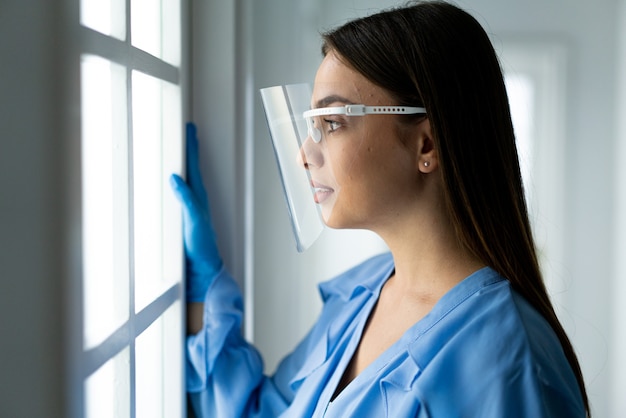 Beautiful young woman with mask inside hospital